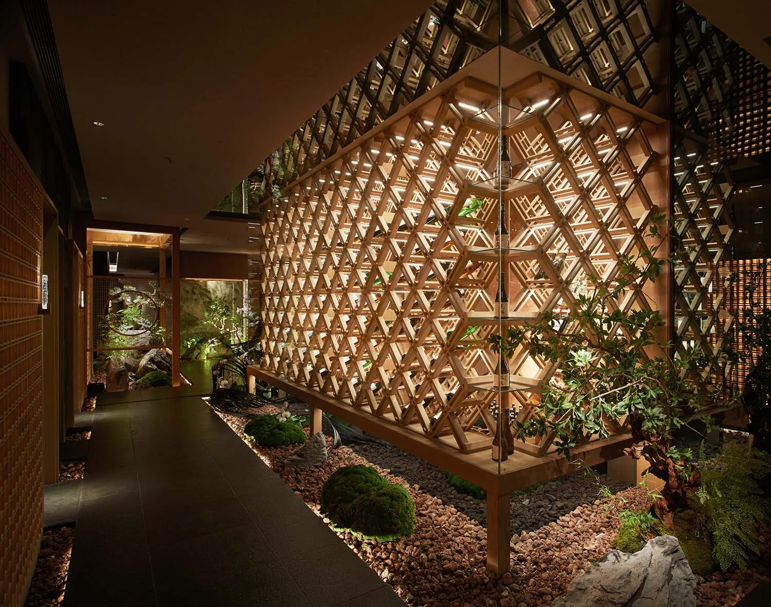 Modern interior space with a wooden honeycomb-patterned wall dividing two rooms, creating a warm and characterful environment