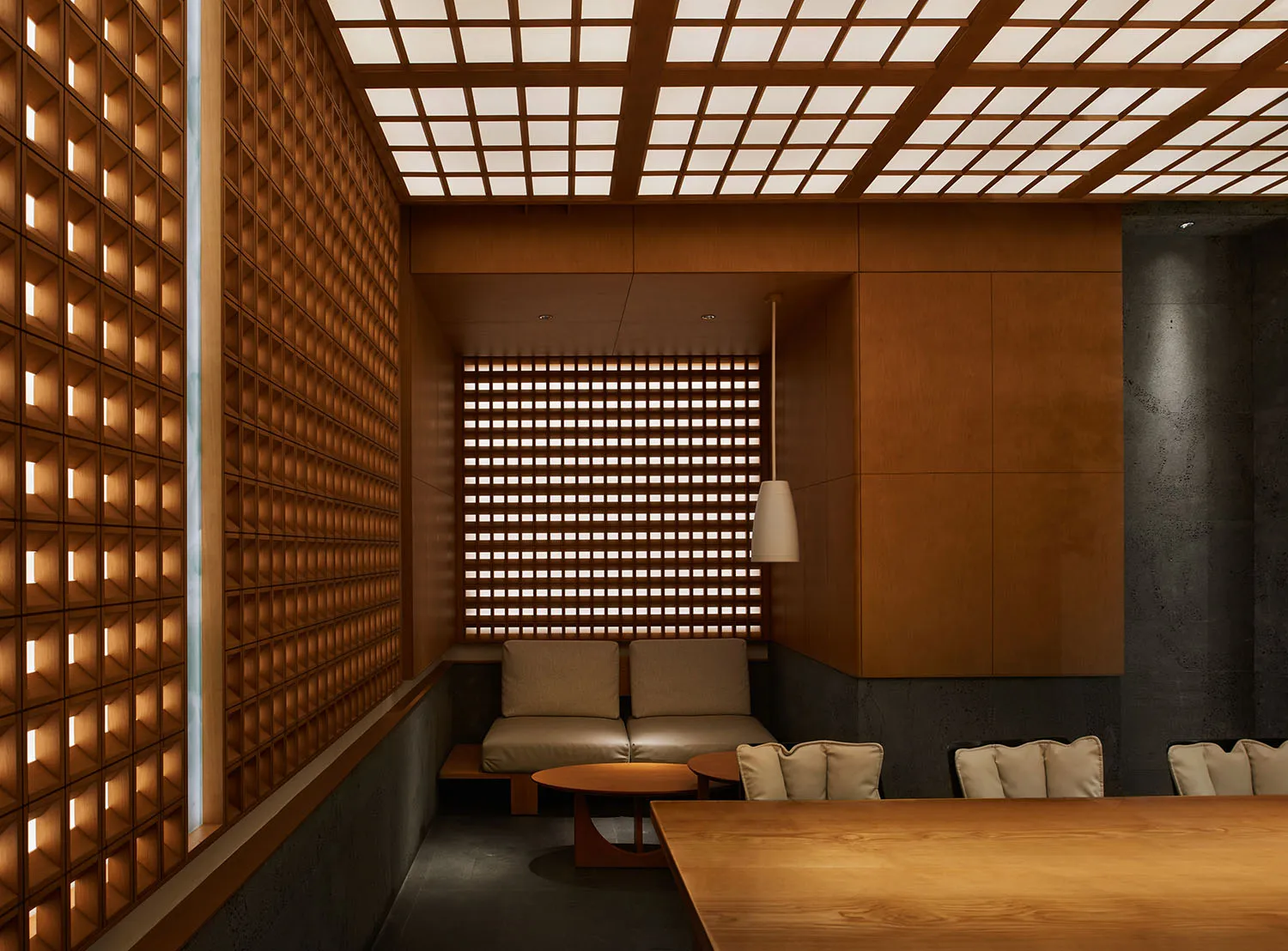 溫馨餐廳內部，木質牆面、金屬點綴，餐桌環繞座椅，燈光柔和