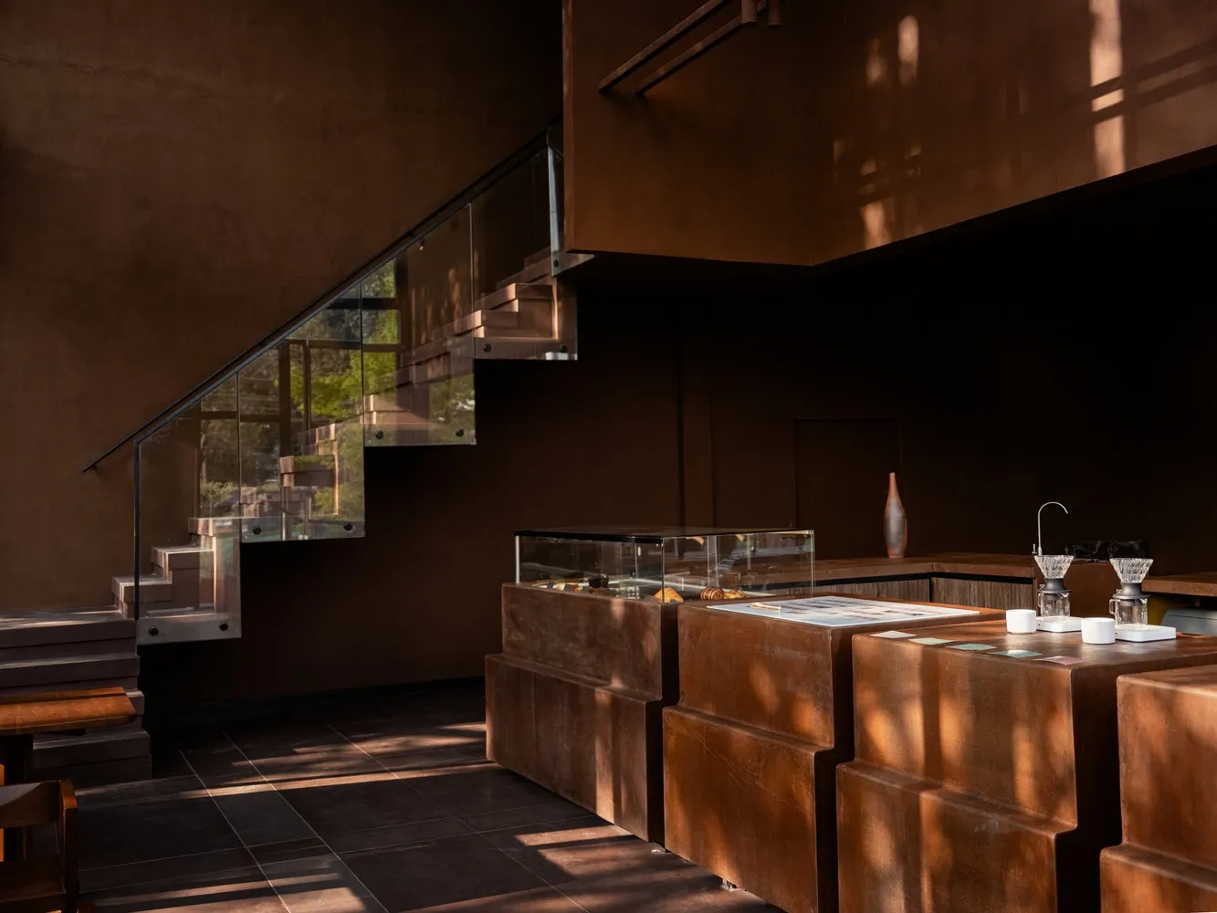 A modern interior space with a sleek staircase leading to a lower level, featuring metal steps and a contemporary design