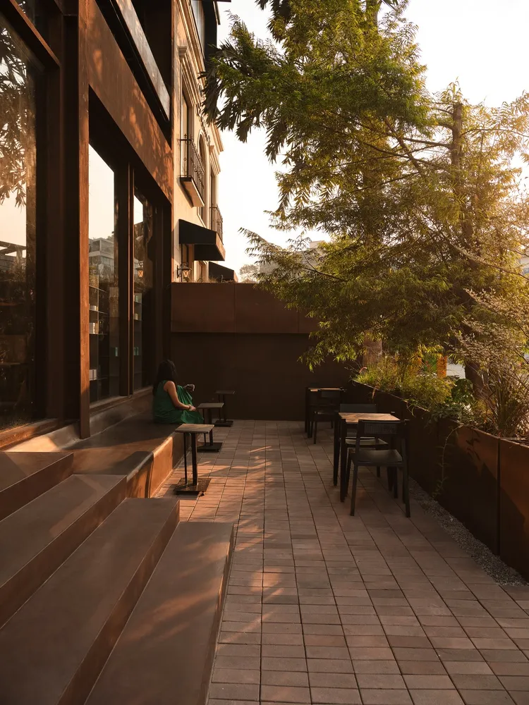 A restaurant patio with wooden benches, tables, and chairs, set in a comfortable and inviting atmosphere