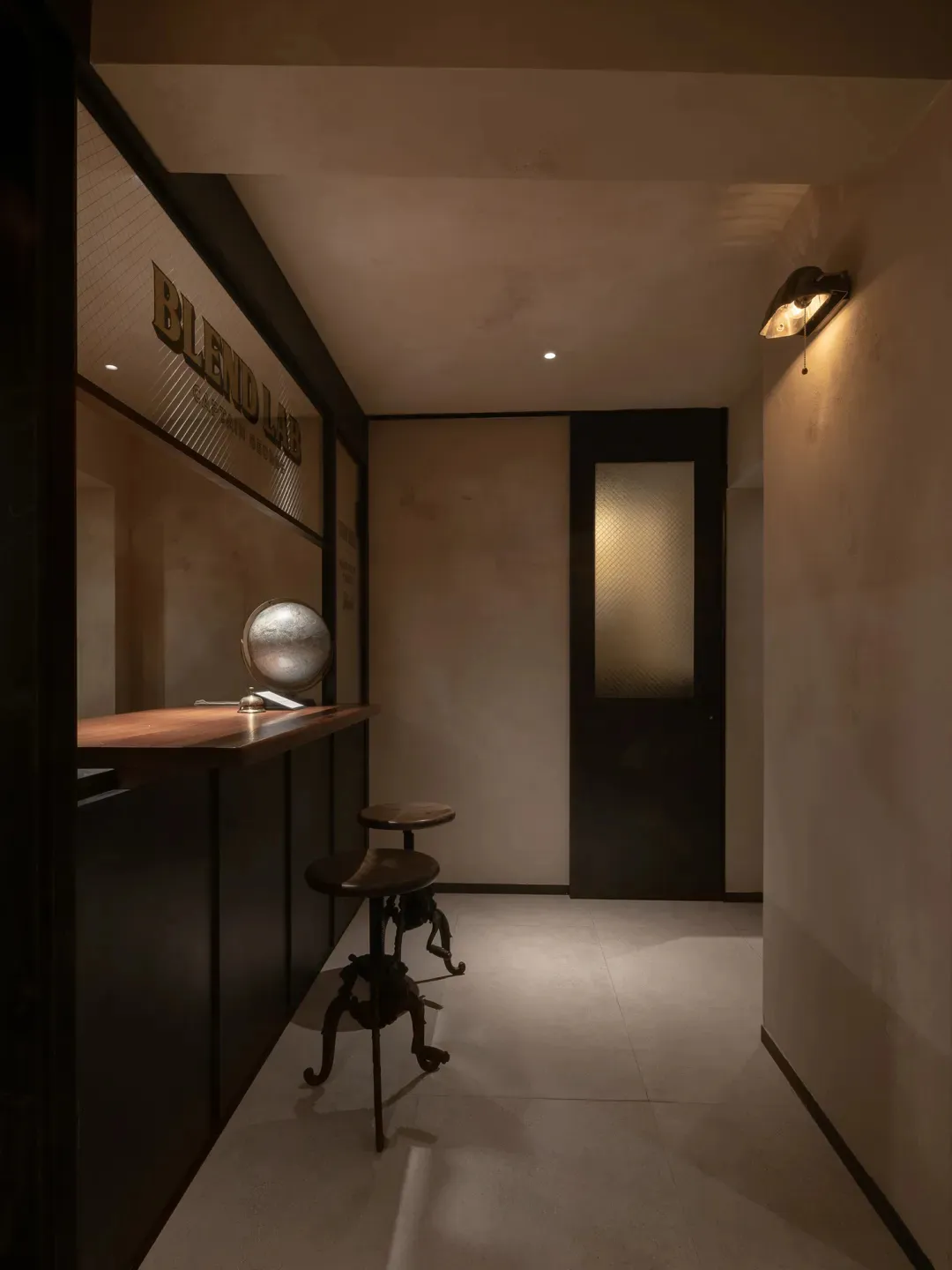 Cozy bar area with a countertop, globe, and two chairs, featuring a sophisticated atmosphere