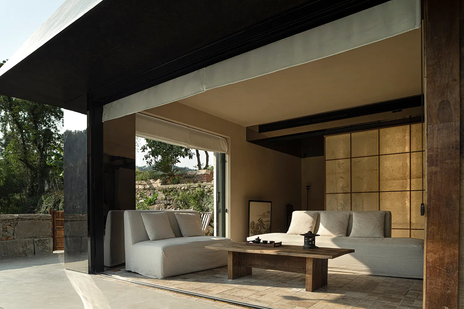 A modern living room with two couches, chairs, and a dining table, featuring a well-lit and inviting atmosphere