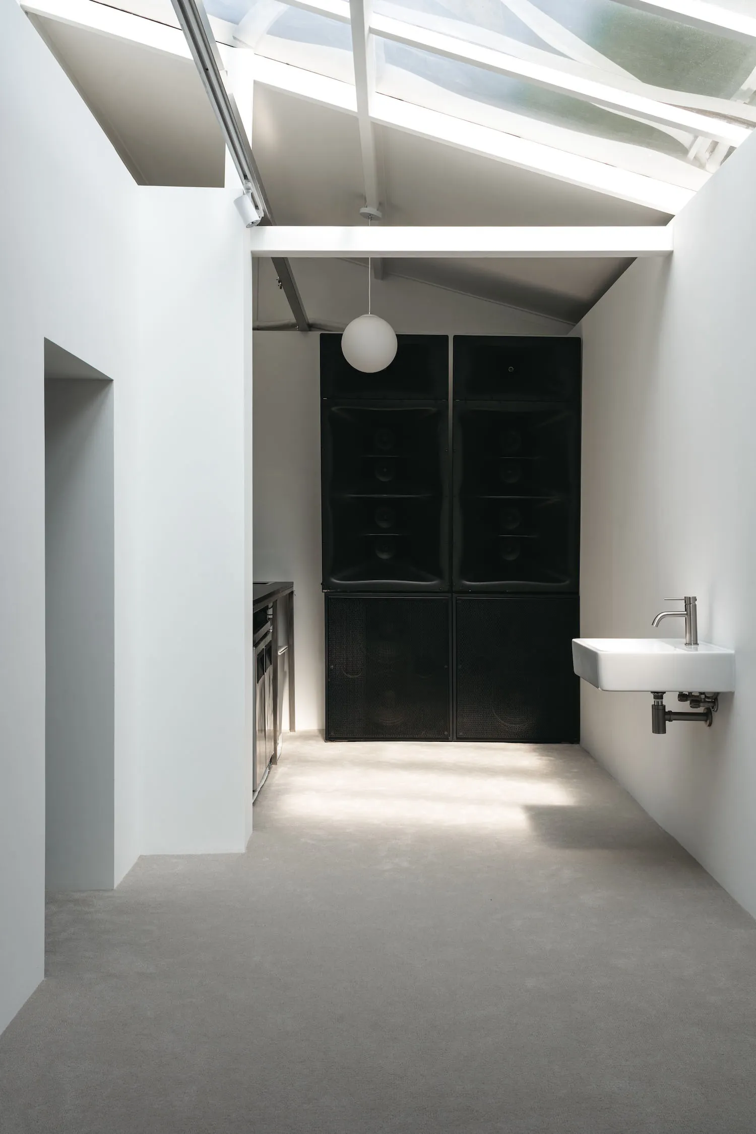 Clean and organized kitchen with two sinks, an oven, and a refrigerator, set against a neutral background