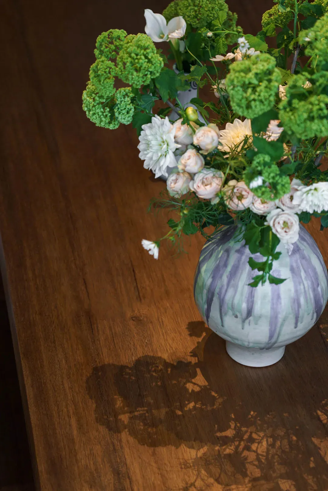 A vase filled with flowers on a wooden table, creating a warm and inviting atmosphere