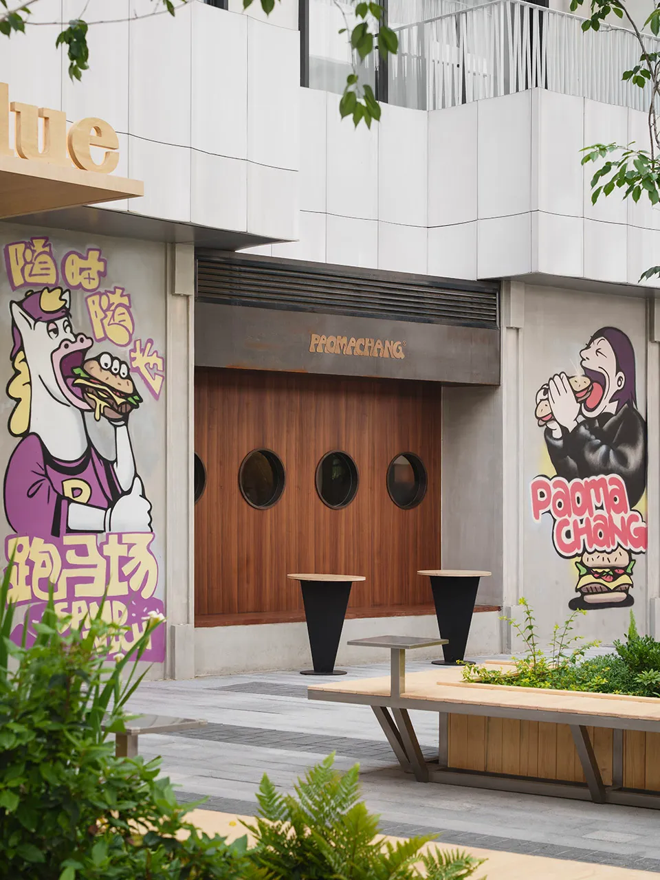 一間現代亞洲餐廳，內有吃三明治的馬匹雕像、木質與混凝土元素，以及牆上各式藝術品，營造溫暖親切的氛圍