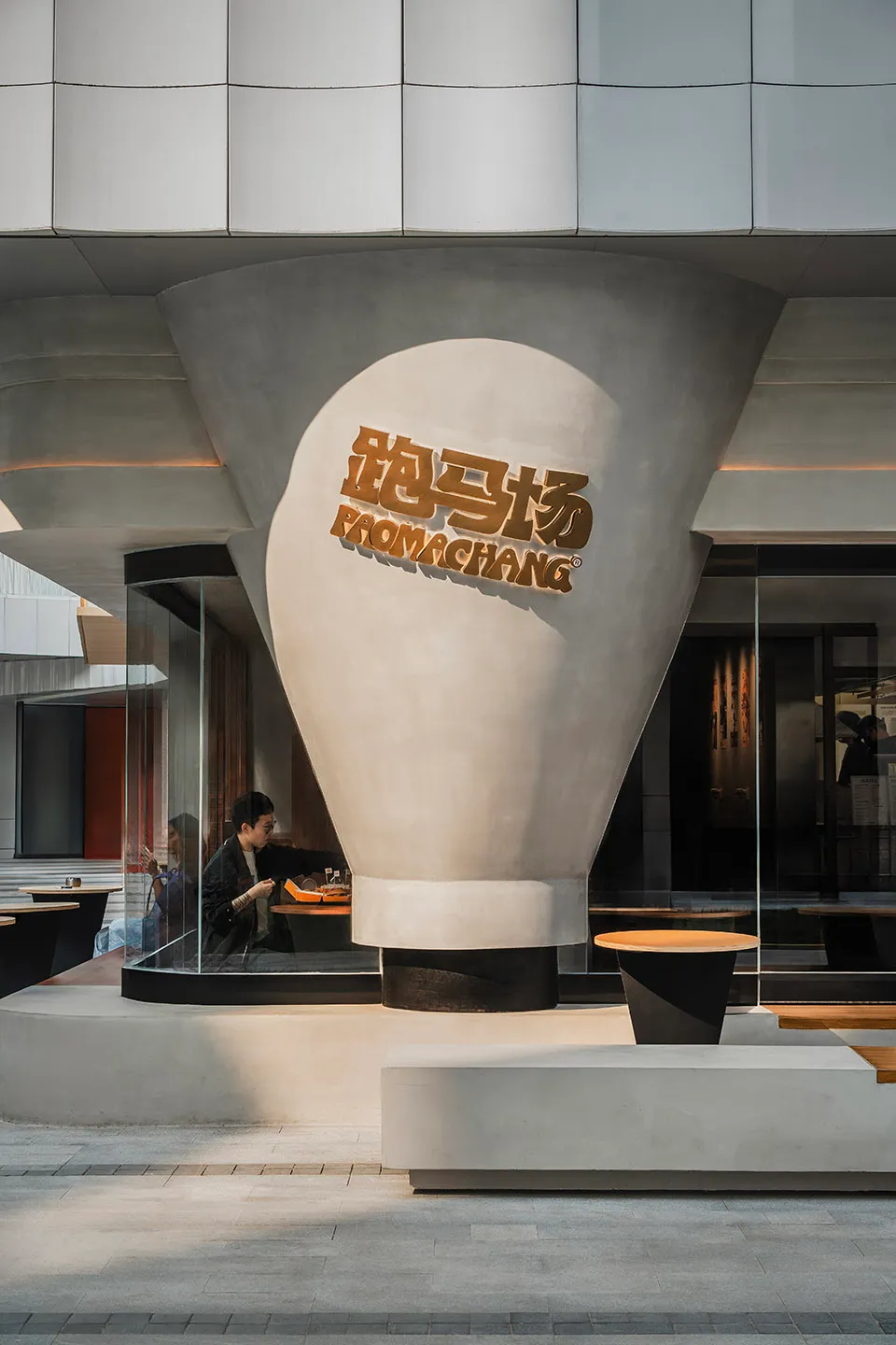 A lively modern Asian restaurant with a large white dome structure, tables, and people enjoying meals