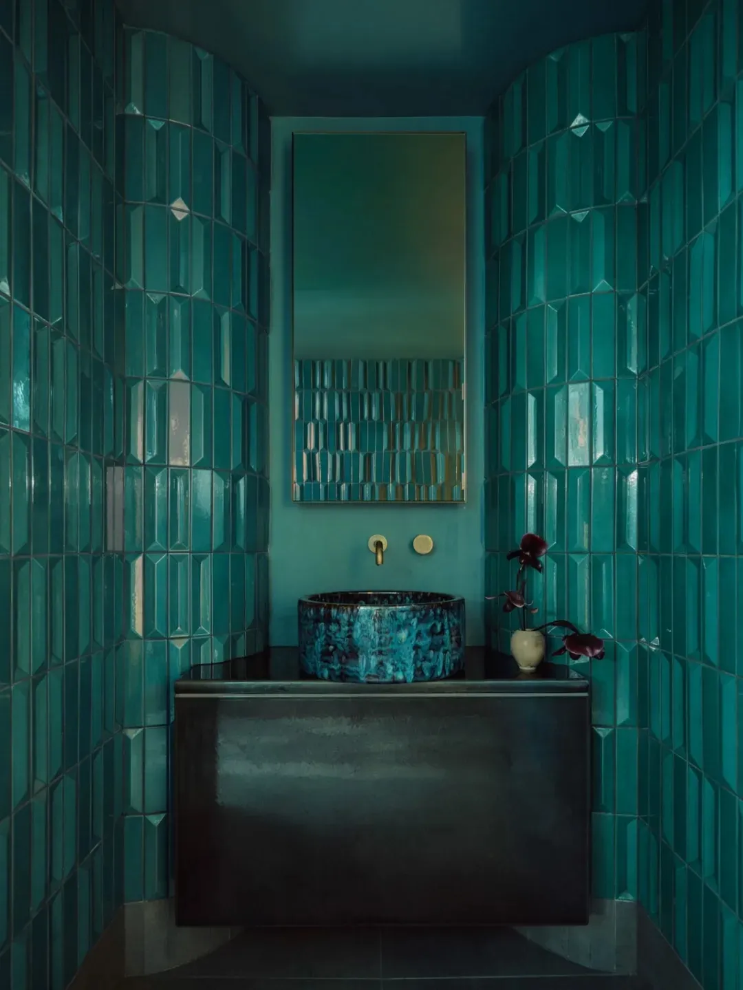A clean and well-organized bathroom with a sink, mirror, and toilet, featuring decorative vases on the countertop and a blue-framed mirror