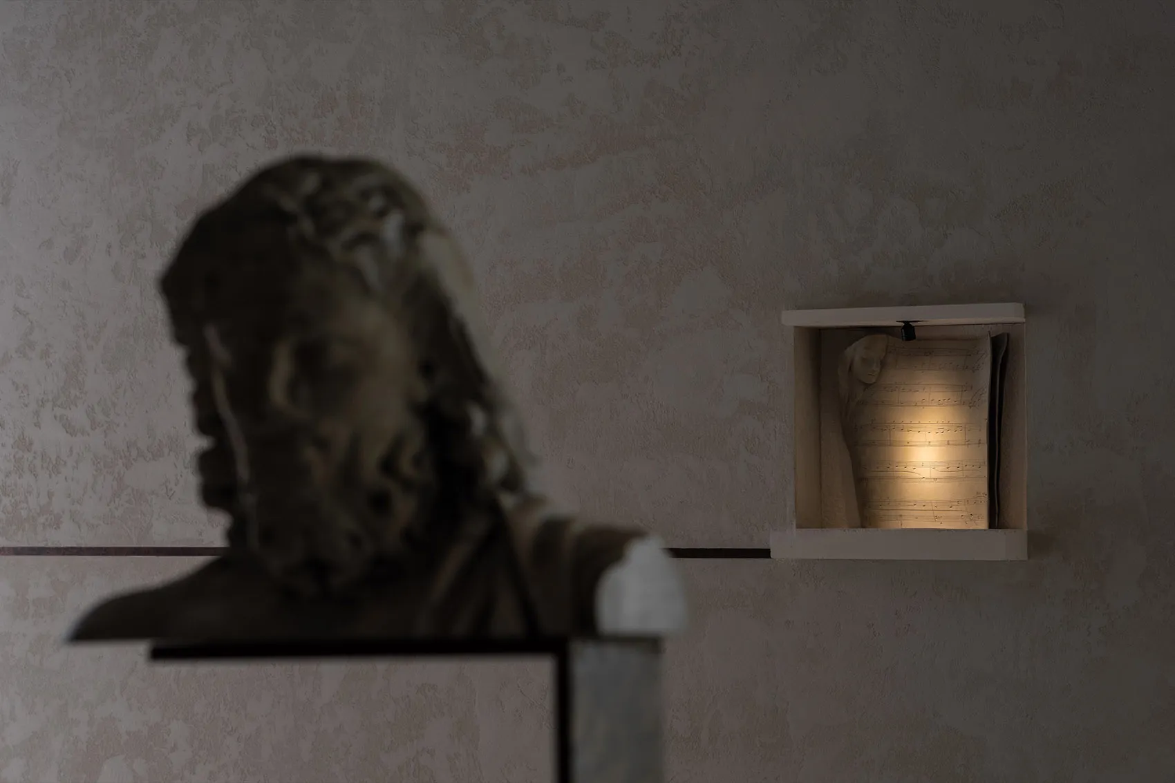 A marble statue of a man's head on display in a museum or gallery setting with a focus on artistic appreciation and historical significance