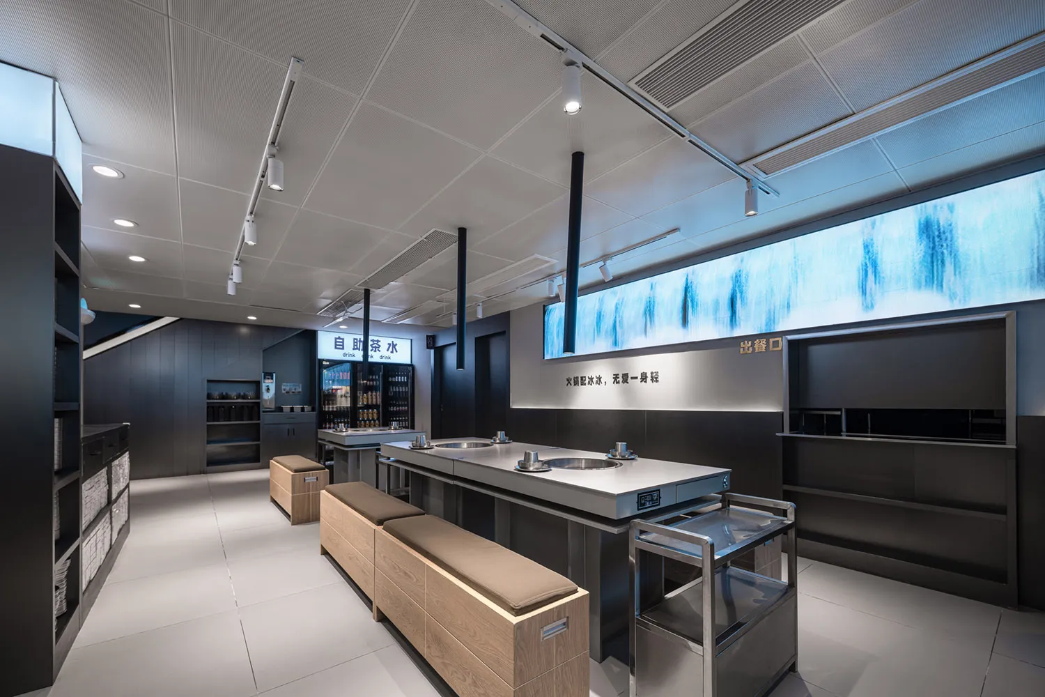 Clean and organized restaurant interior with a large counter, wooden benches, and bottles and cups on surfaces