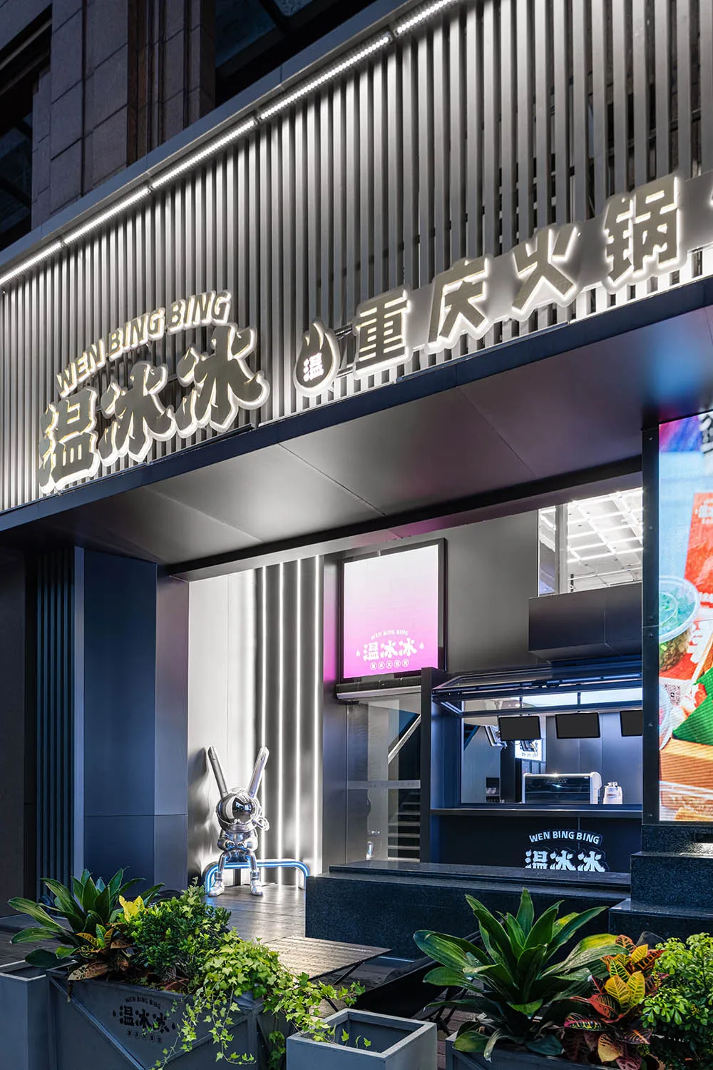 現代亞洲餐廳，黑色檯面、自然光線與牆面電視螢幕