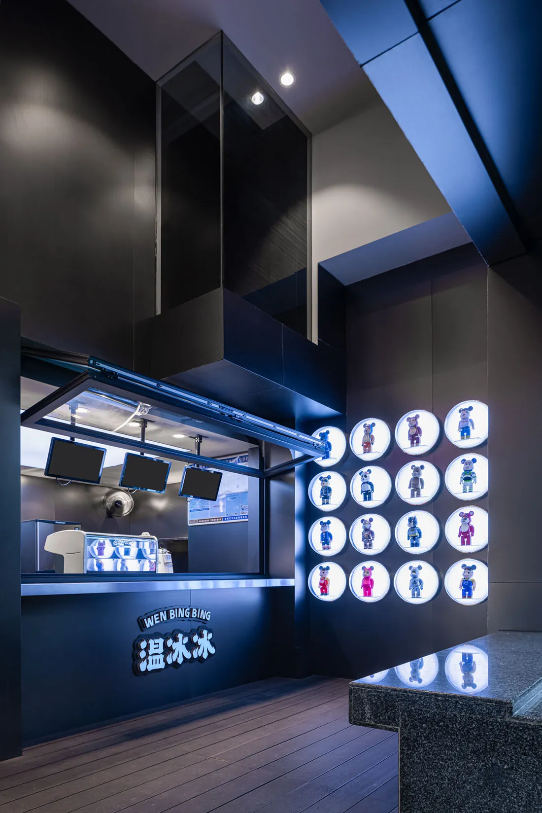 A lively restaurant interior with black walls, brightly lit, and teddy bears arranged around the area