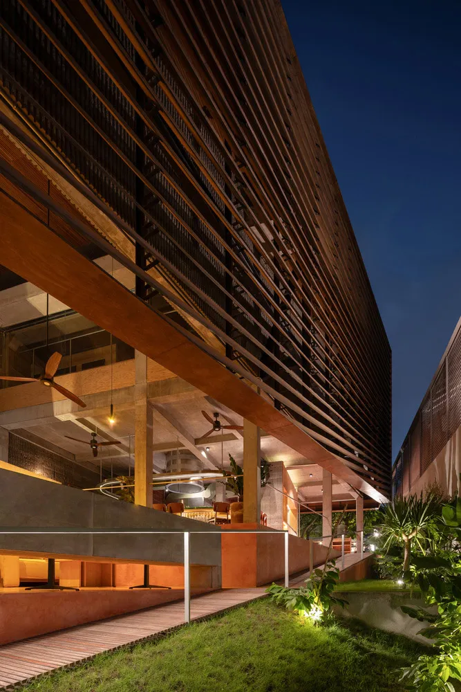 Modern building with a wooden exterior, featuring multiple windows, balconies, and a warm atmosphere with natural light