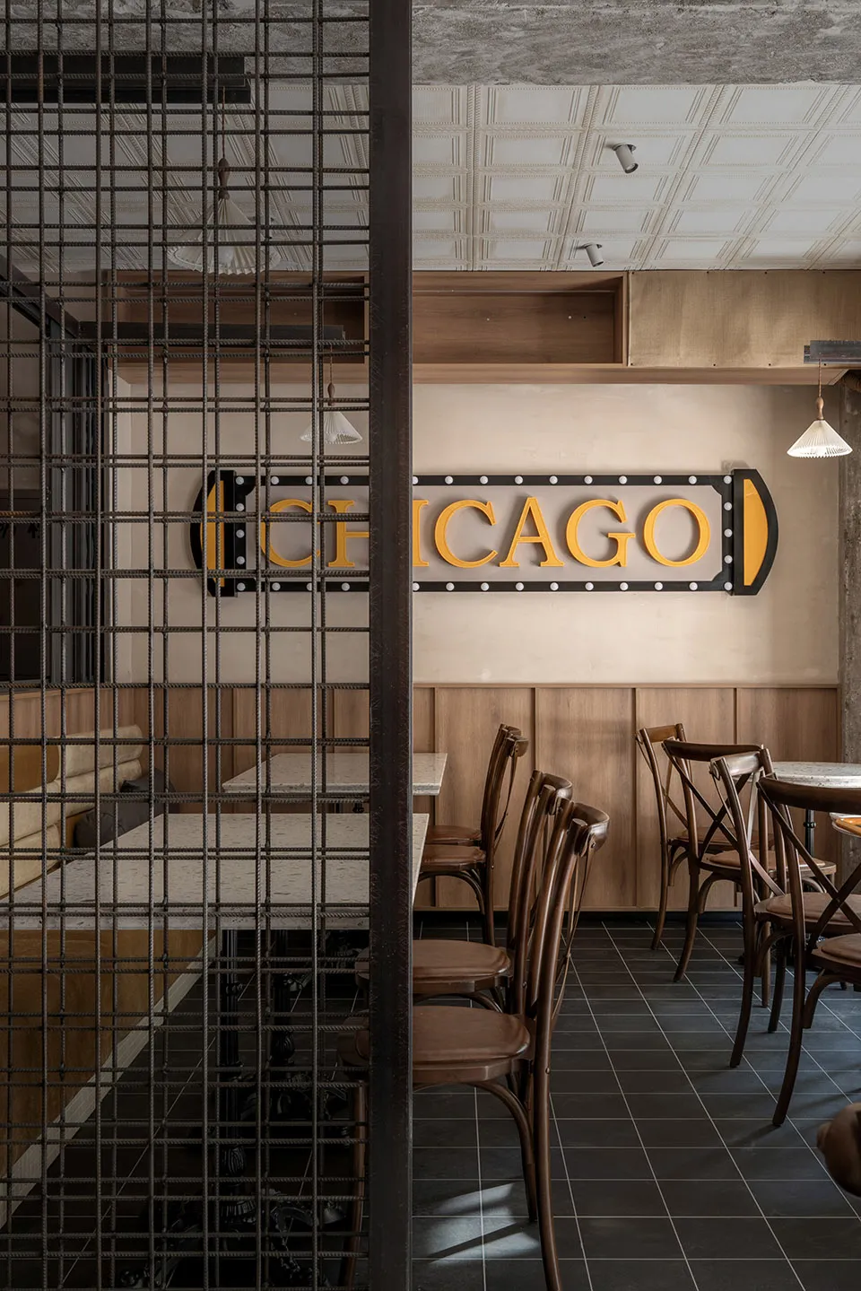 Cozy restaurant dining space with wooden walls, multiple tables, and chairs, featuring a warm and inviting atmosphere