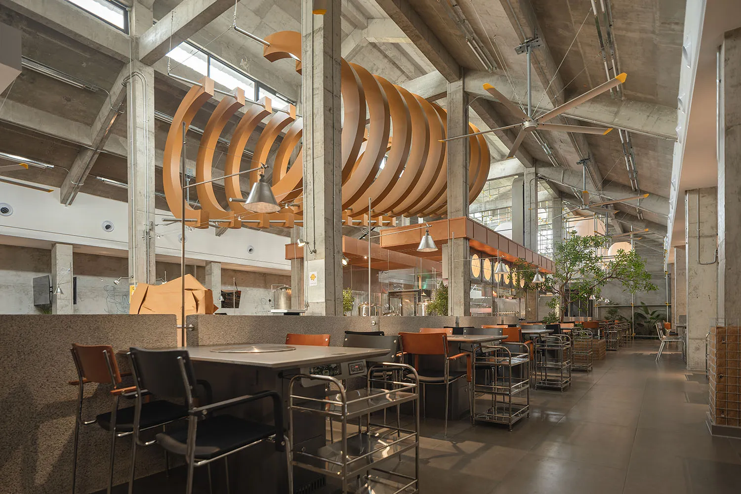 A well-lit restaurant interior with modern design, multiple dining tables, and comfortable seating options