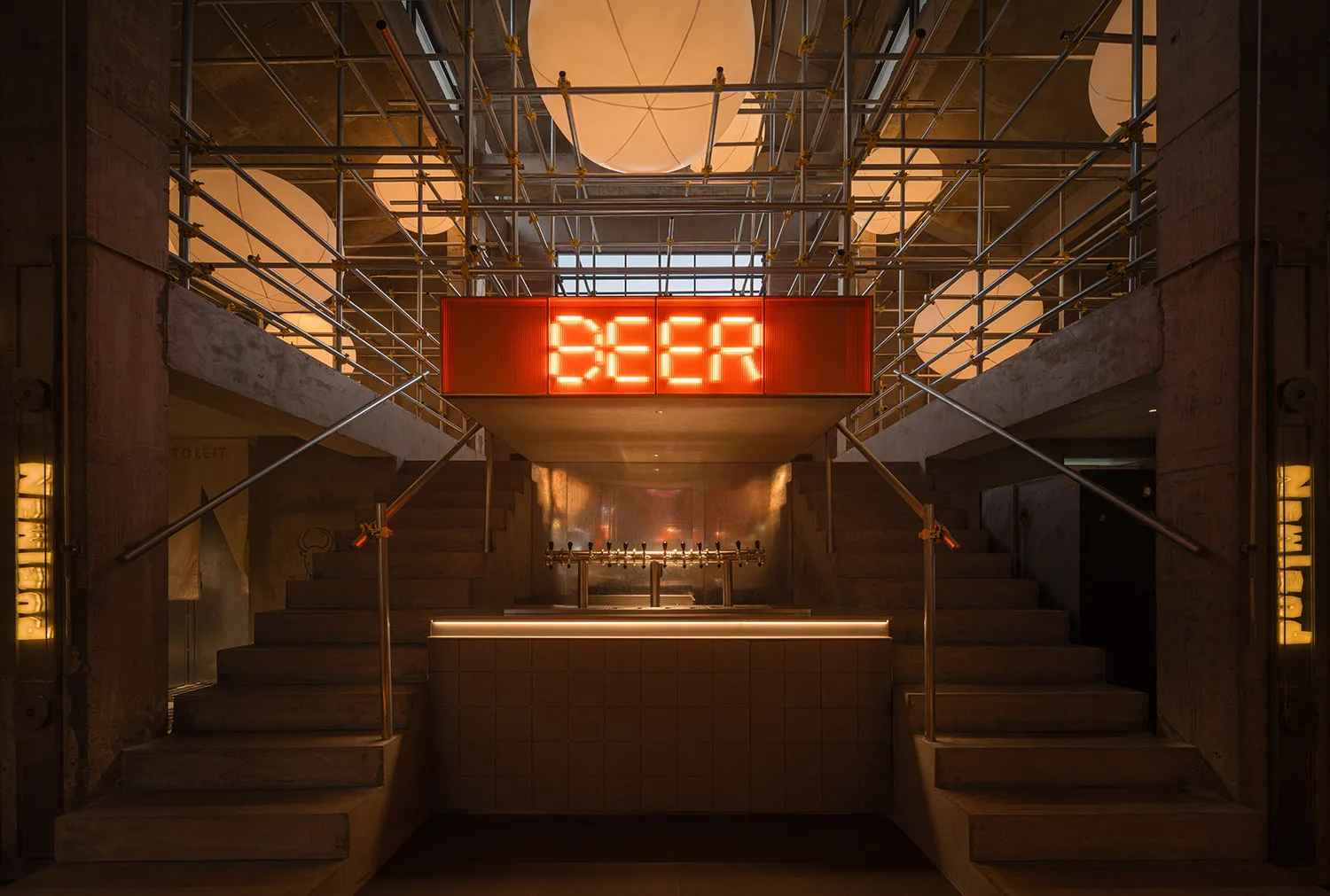 Casual industrial bar with beer taps, wooden accents, and a large sign reading Beer