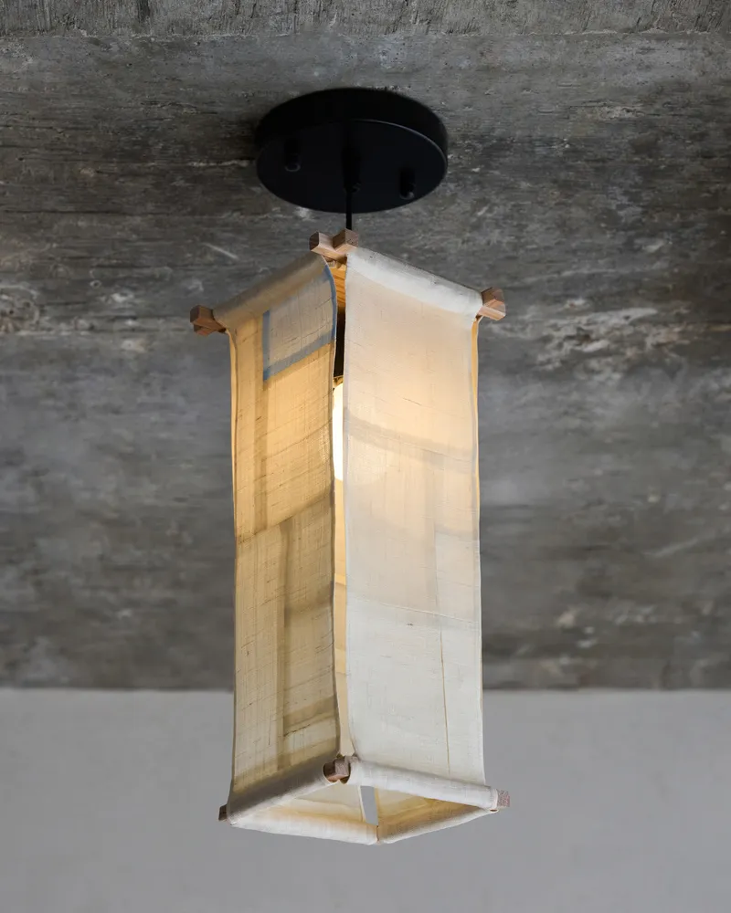 A modern room with a wooden lamp suspended from the ceiling and a concrete wall adding a modern touch