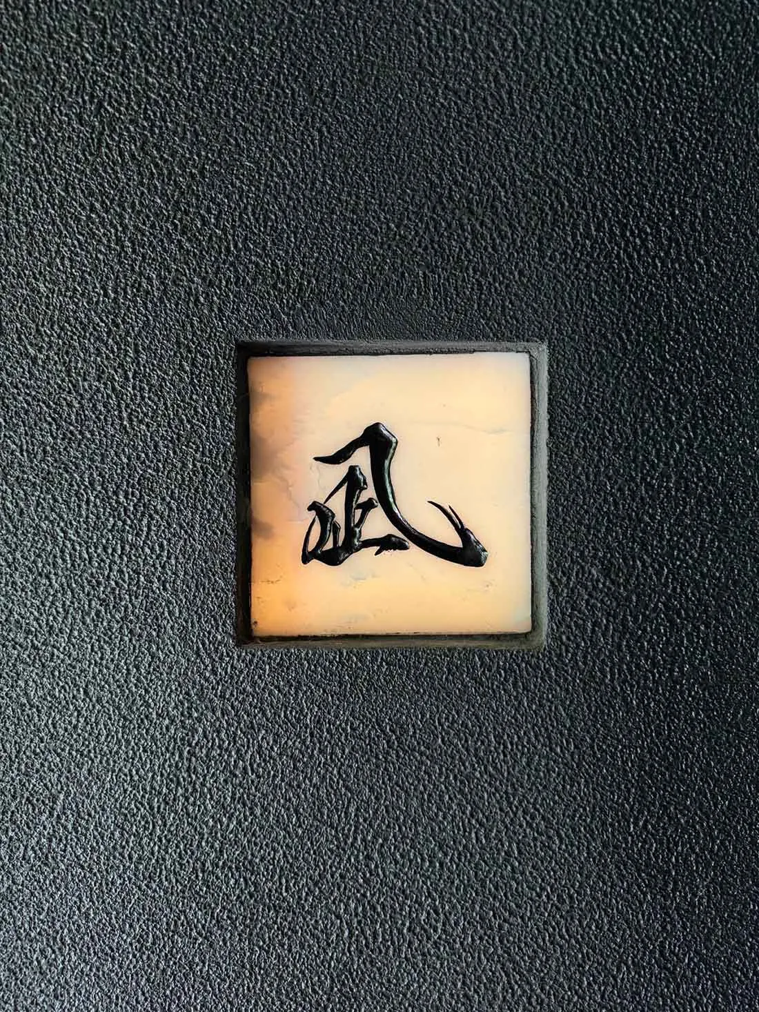 A black background with a white square containing Chinese characters in an oriental design, suggesting a cultural and artistic theme