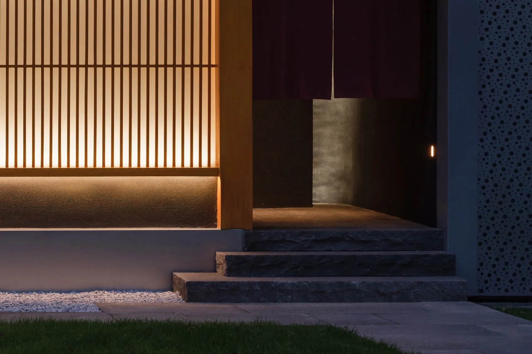 Asian-style building with wooden doorway, wooden fence, and stone wall, set in a calm and serene environment