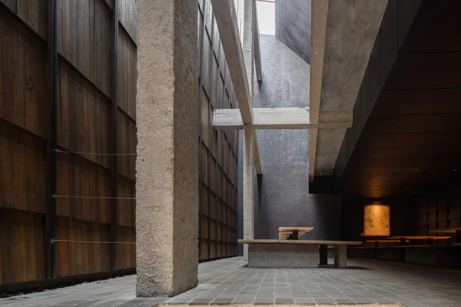 A calm and inviting interior space with a brick-patterned wall, a bench, and natural light