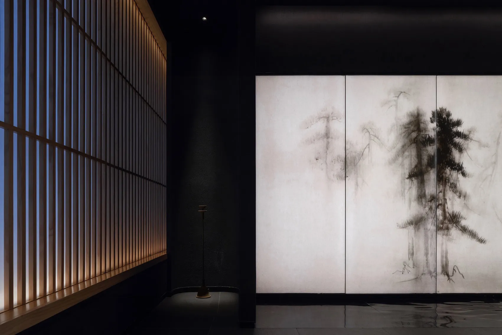 A serene room with a tree mural on the wall, a vase, and a calm atmosphere