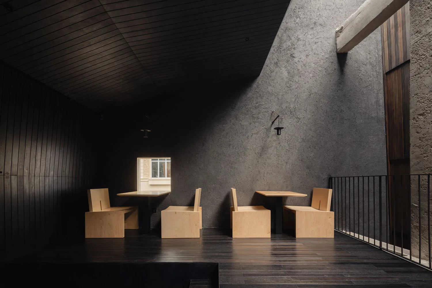 Cozy modern living and dining space with grey walls, wooden floors, and a dining table surrounded by chairs