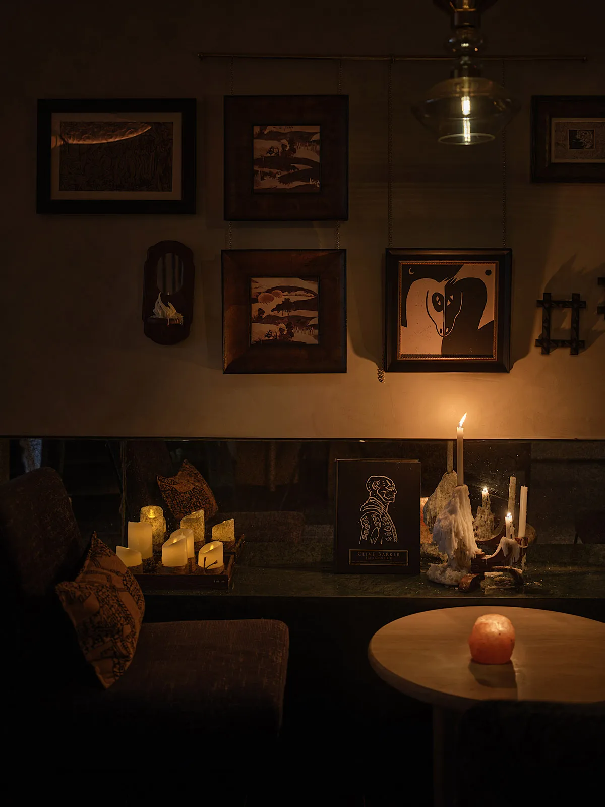 A cozy dining area with a table, chairs, and numerous hanging photos on the wall, creating a warm and inviting atmosphere