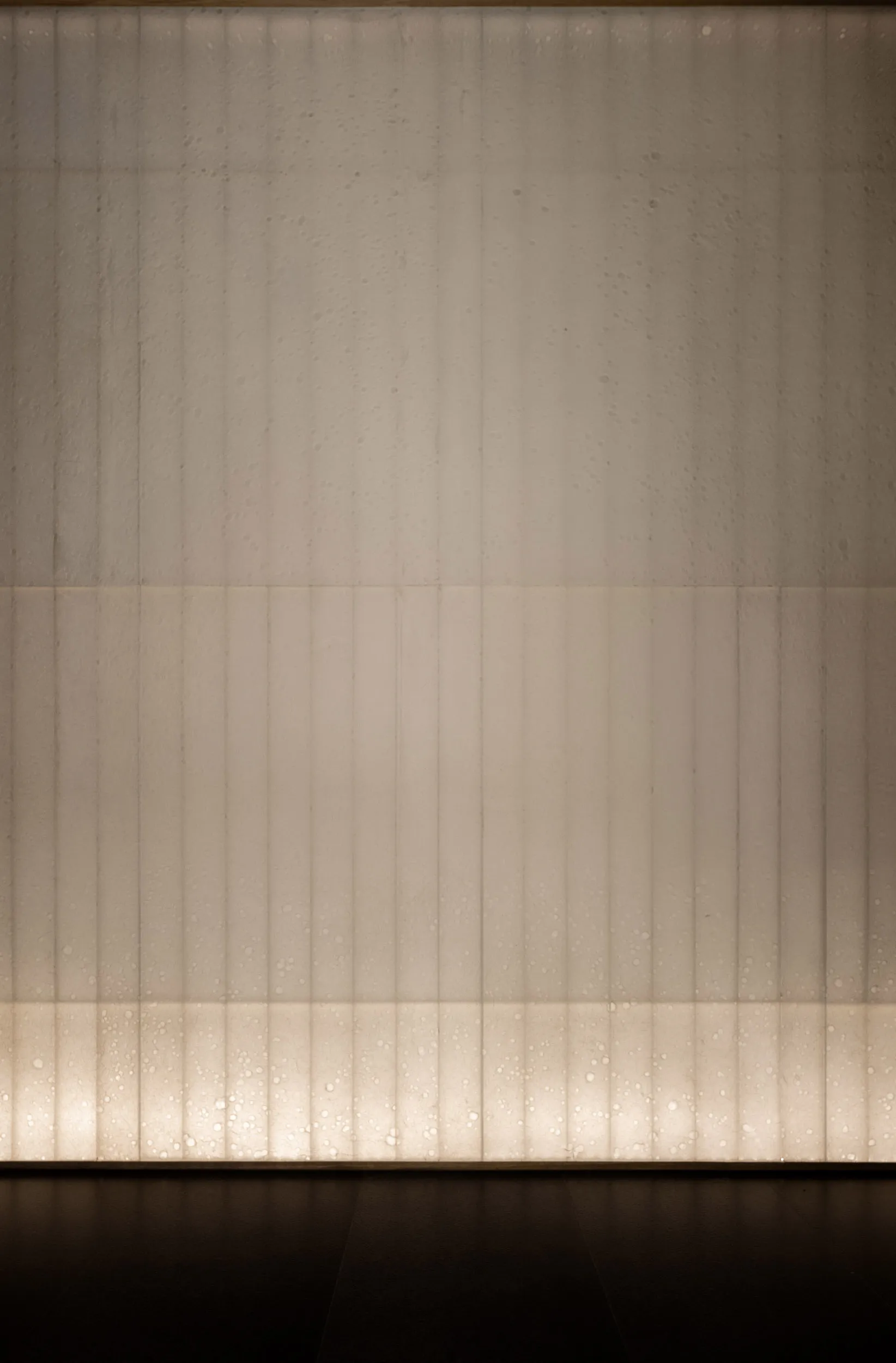 A concrete wall with a row of evenly spaced small windows, creating a functional and practical design