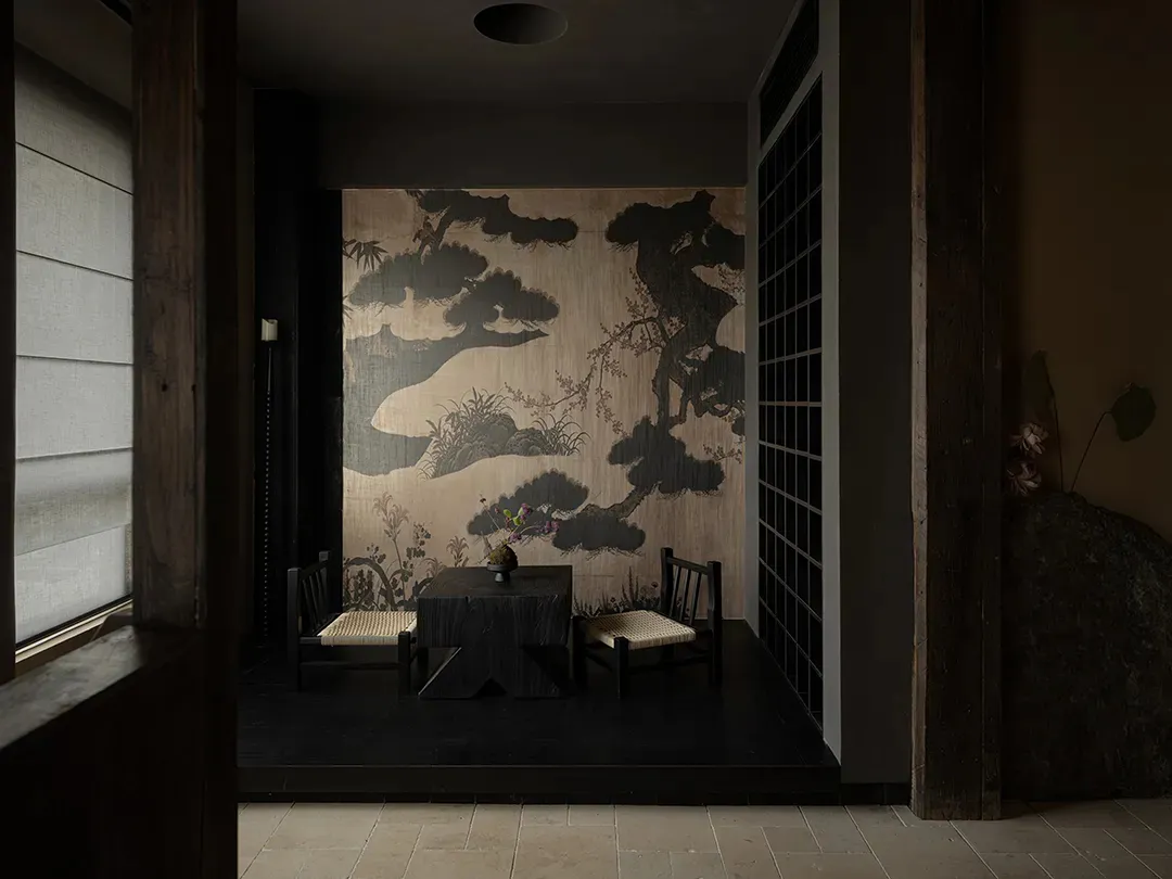 Cozy dining space with Asian-inspired decor, a dining table, chairs, and artwork on the walls, dimly lit for a warm ambiance