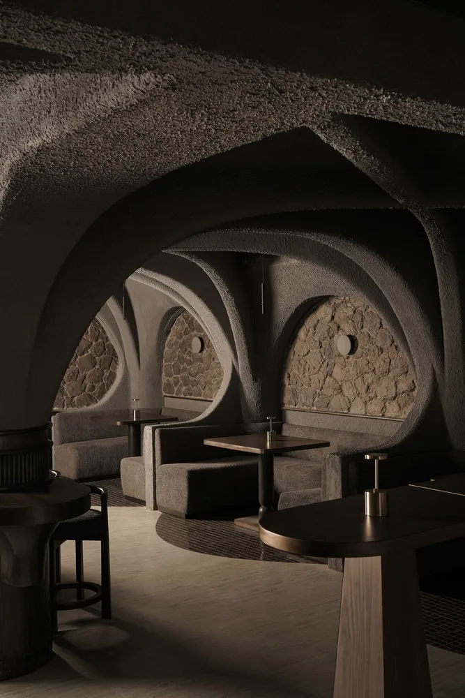 Cozy restaurant interior with stone walls, wooden furniture, and warm lighting