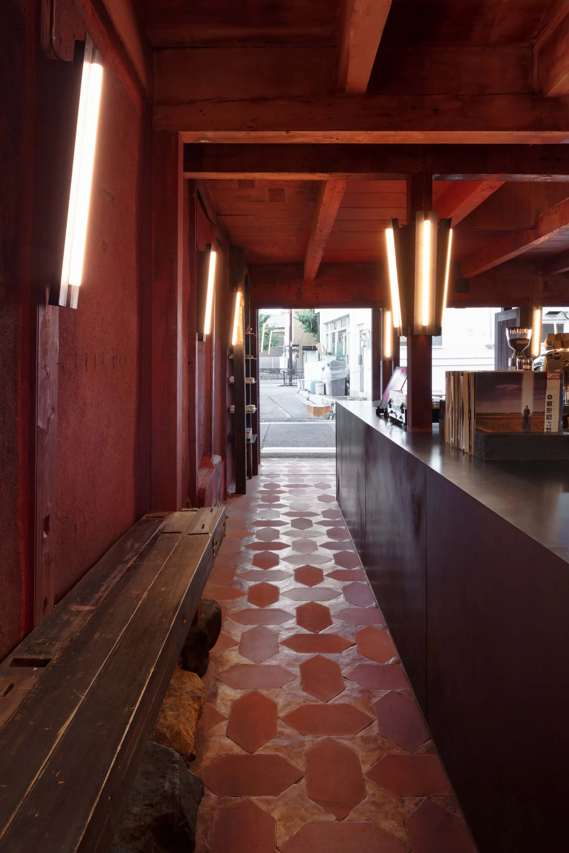 A warm and inviting cafe interior with a red brick wall, black countertop, and seating areas
