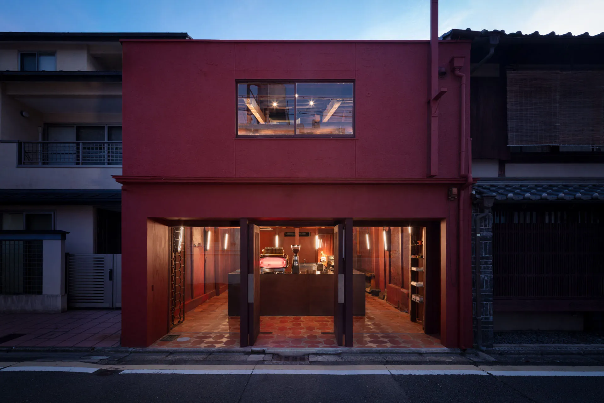 Inviting restaurant interior with a red exterior wall, dining tables, chairs, and cups, providing a comfortable dining experience