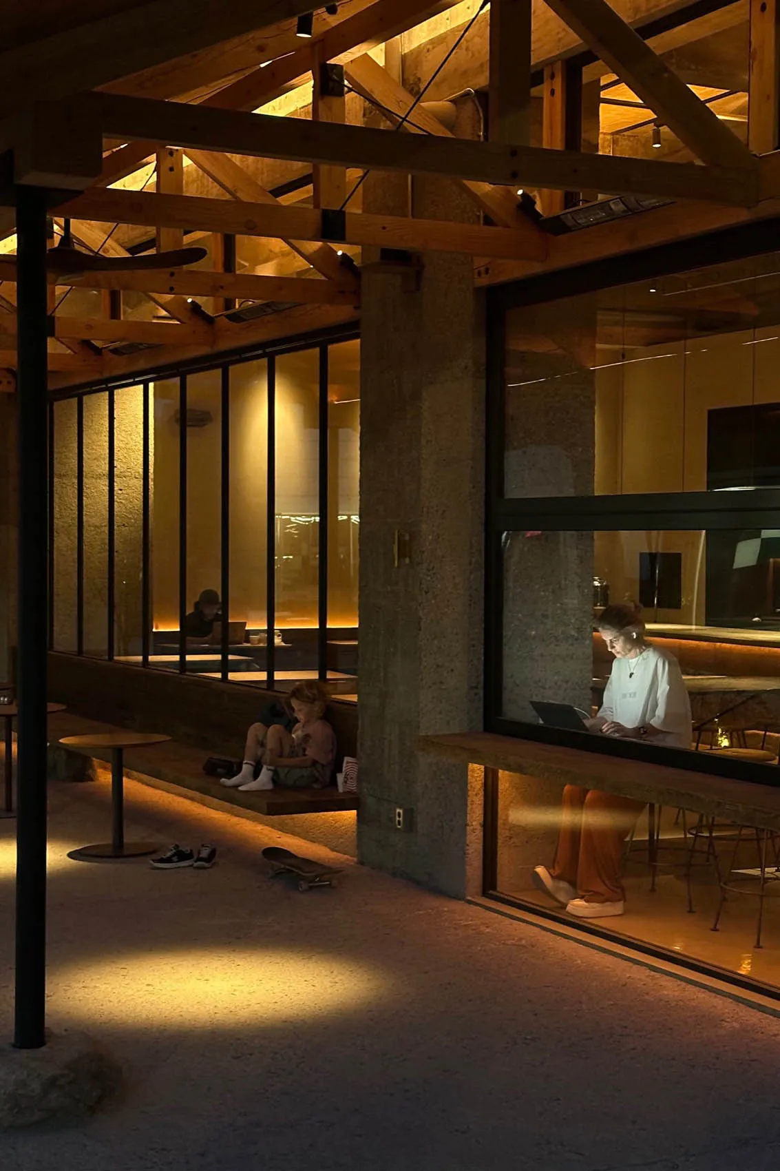 A bustling cafe with people eating, working, and socializing in a modern space with comfortable seating and technology