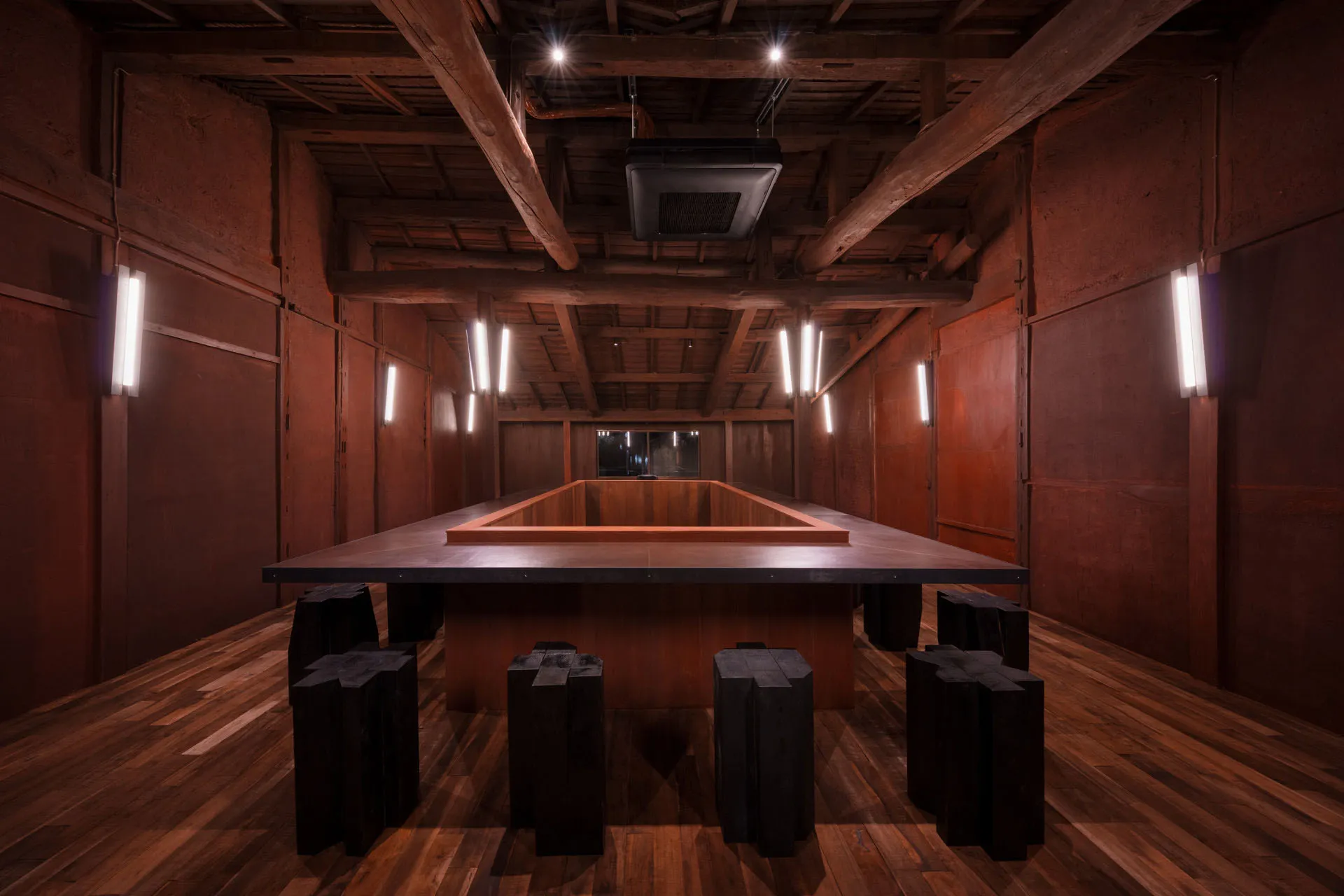 A restaurant and bar area with wooden paneling, dining tables, chairs, and lighting fixtures creating a warm and inviting atmosphere