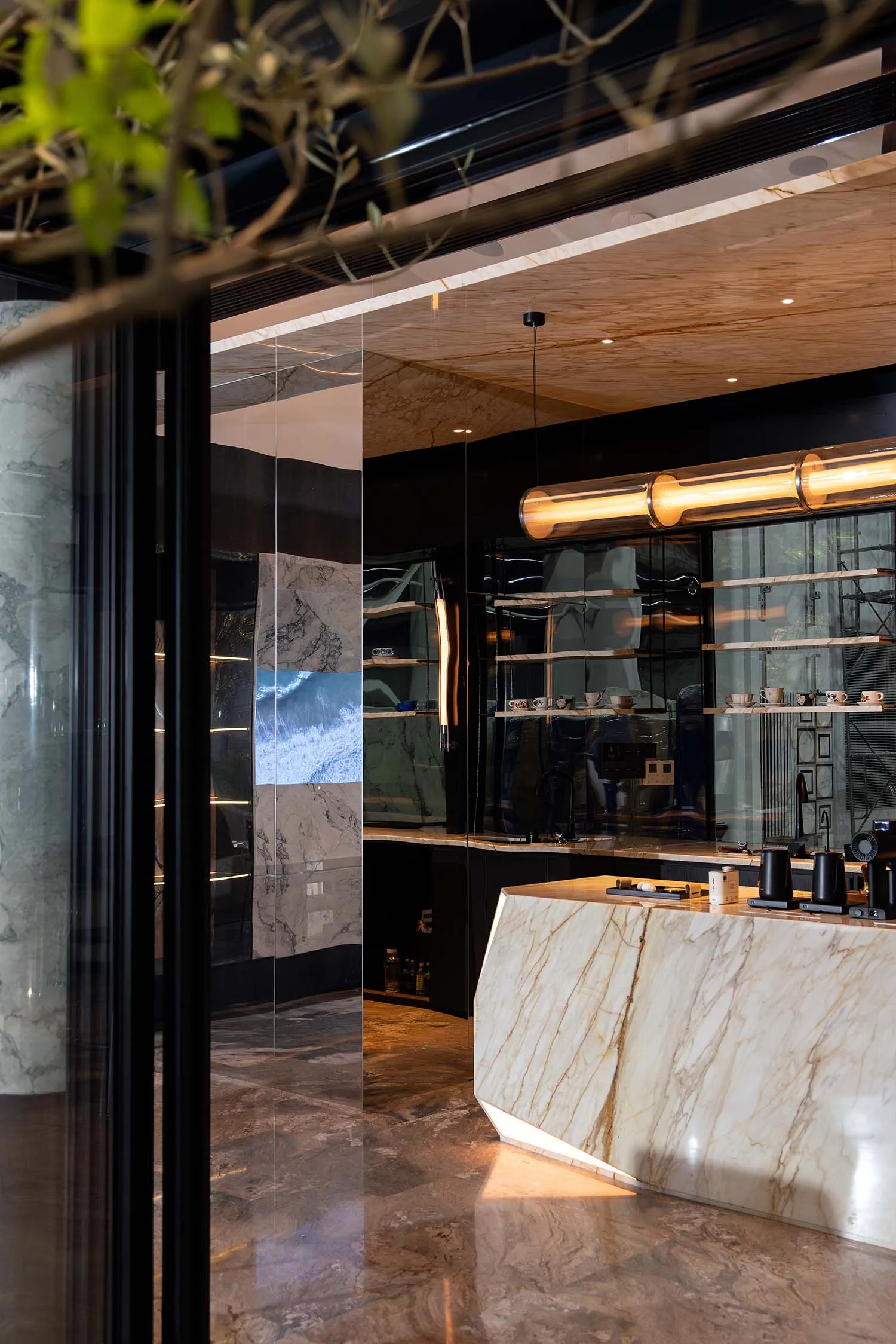 Modern interior design showroom with a marble countertop bar area, featuring cups and a bottle, and a sophisticated atmosphere