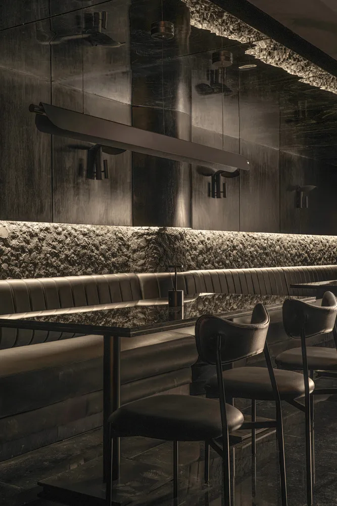 Modern restaurant bar with black leather chairs and tables, surrounded by a stylish and sophisticated atmosphere