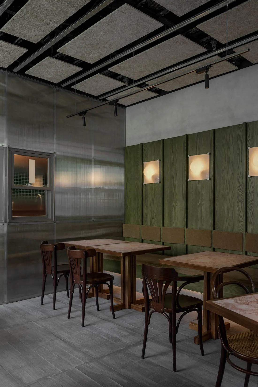 Inviting restaurant interior with green walls, wooden tables and chairs, and comfortable seating for guests