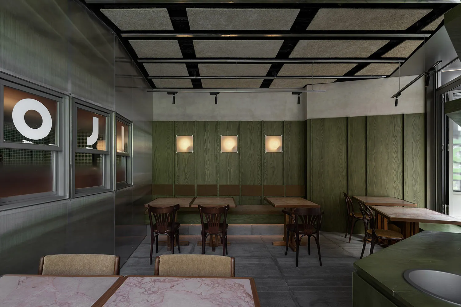 Warm and inviting cafe interior with wooden walls, marble tables, and comfortable seating