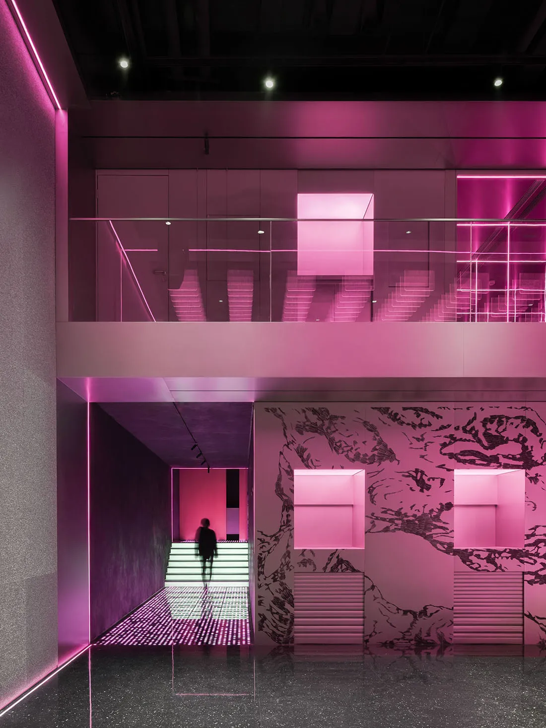 A pink and white room with a staircase, two people, and a mix of pink and white colors creating a unique atmosphere