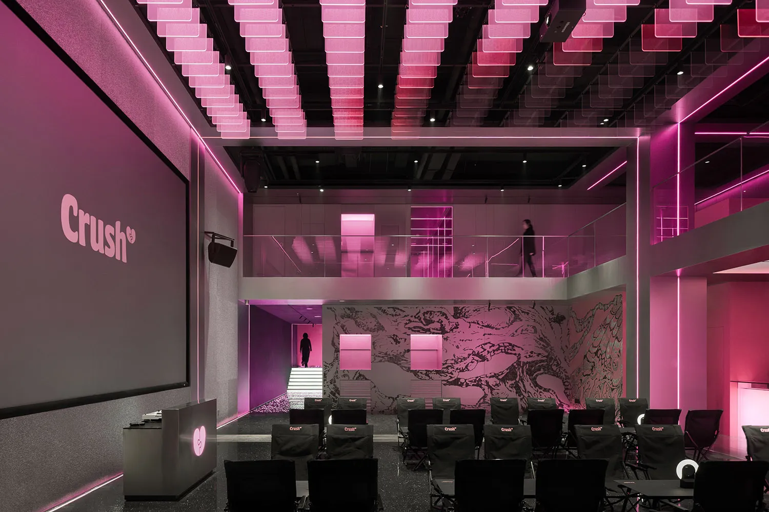 A modern lobby with a pink building, rows of chairs, and a stylish atmosphere