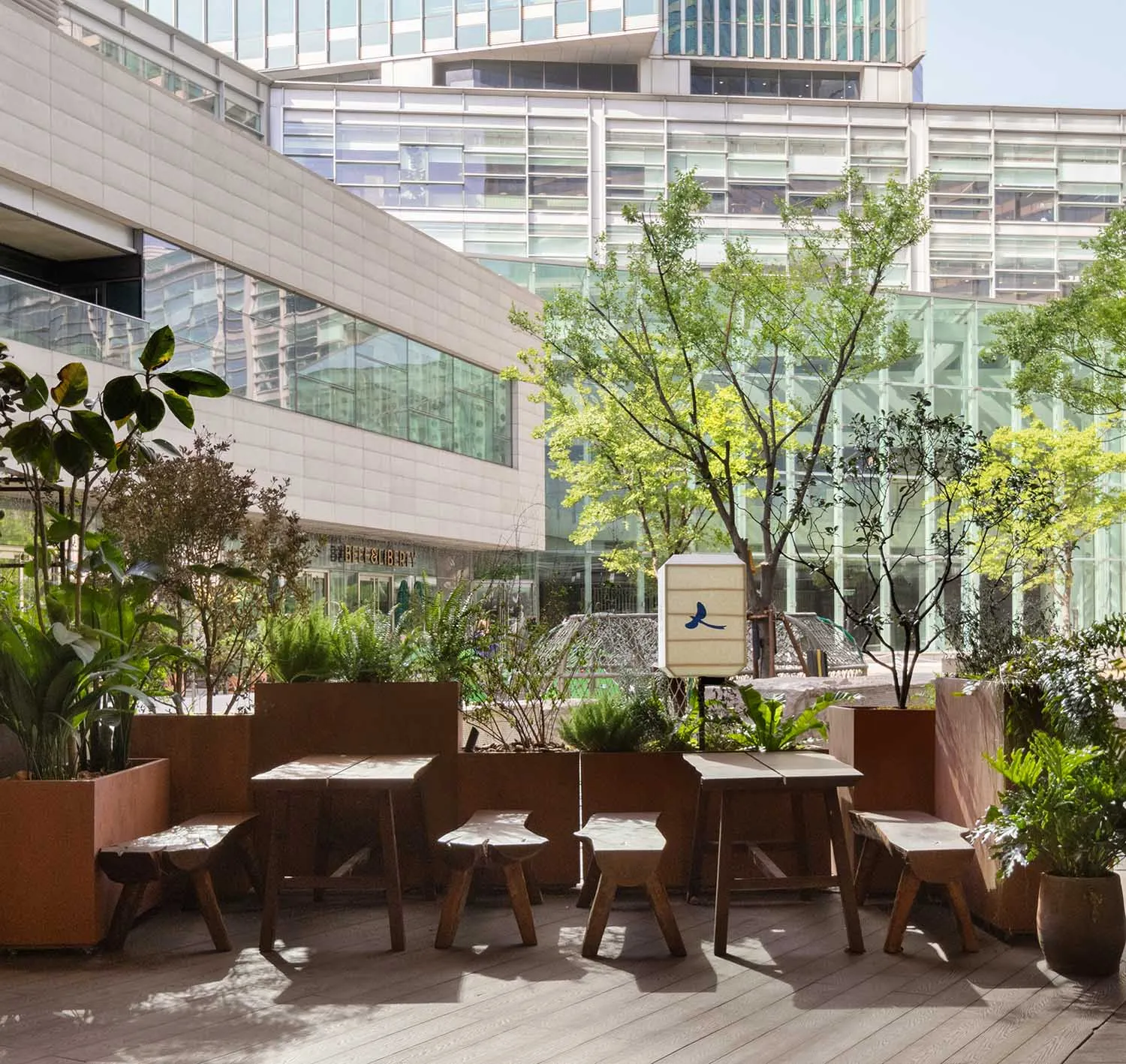 A casual outdoor patio with multiple wooden tables and chairs, perfect for socializing and enjoying meals or conversations