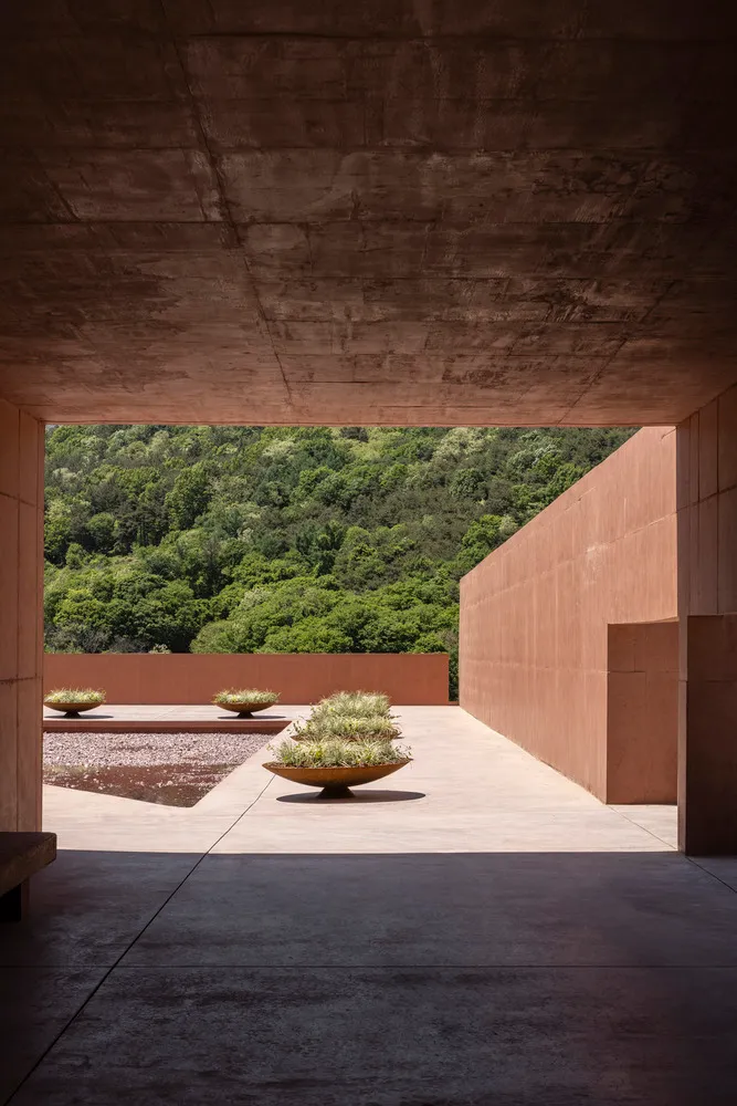 A grand building with a stone facade, featuring three vases on the ground outside, adding to its aesthetic appeal