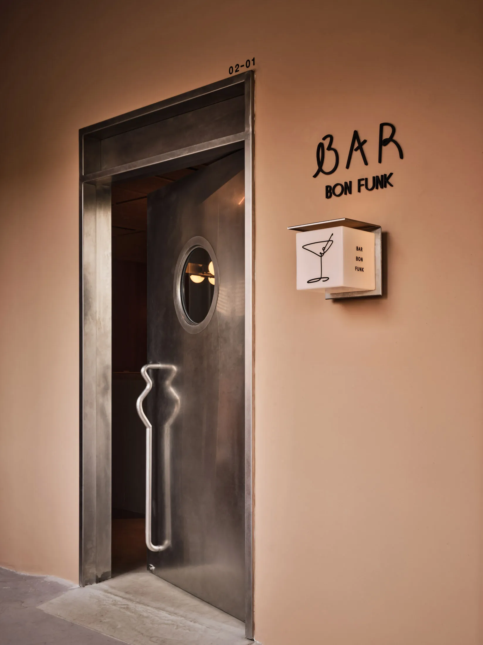 A metal door with a keyhole in a modern bar or restaurant setting