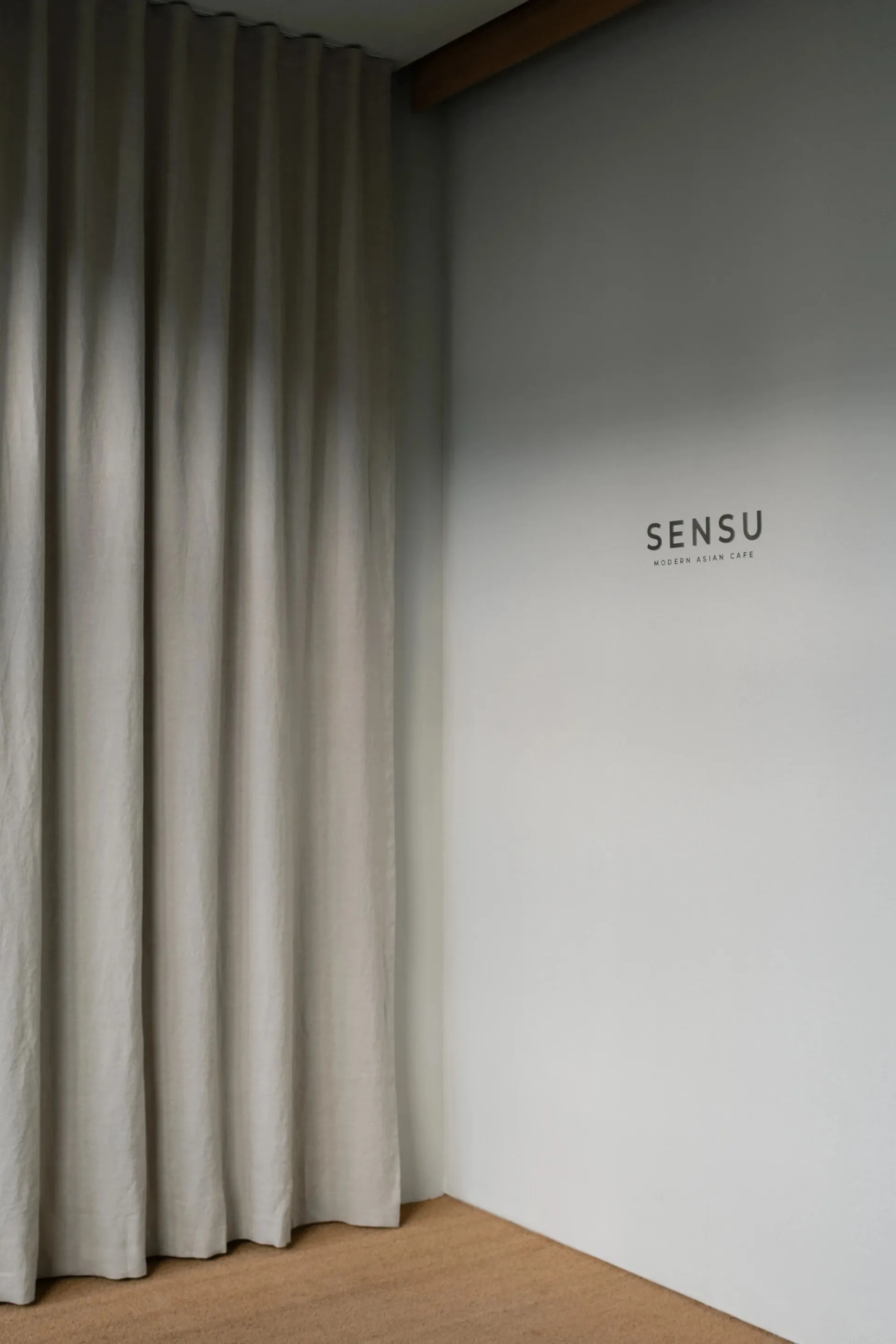 A white room with a linen curtain hanging on a wall, with no other objects or details visible