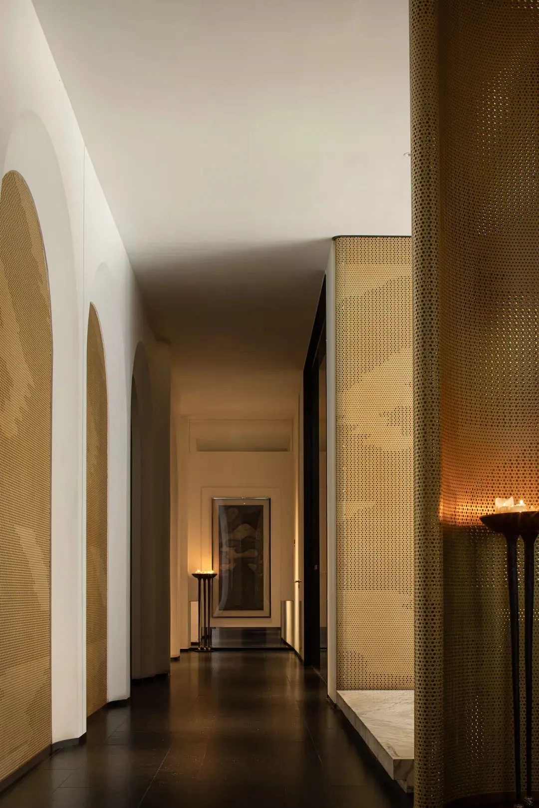 A dimly lit hallway with a patterned wall, two doors, and a mysterious atmosphere