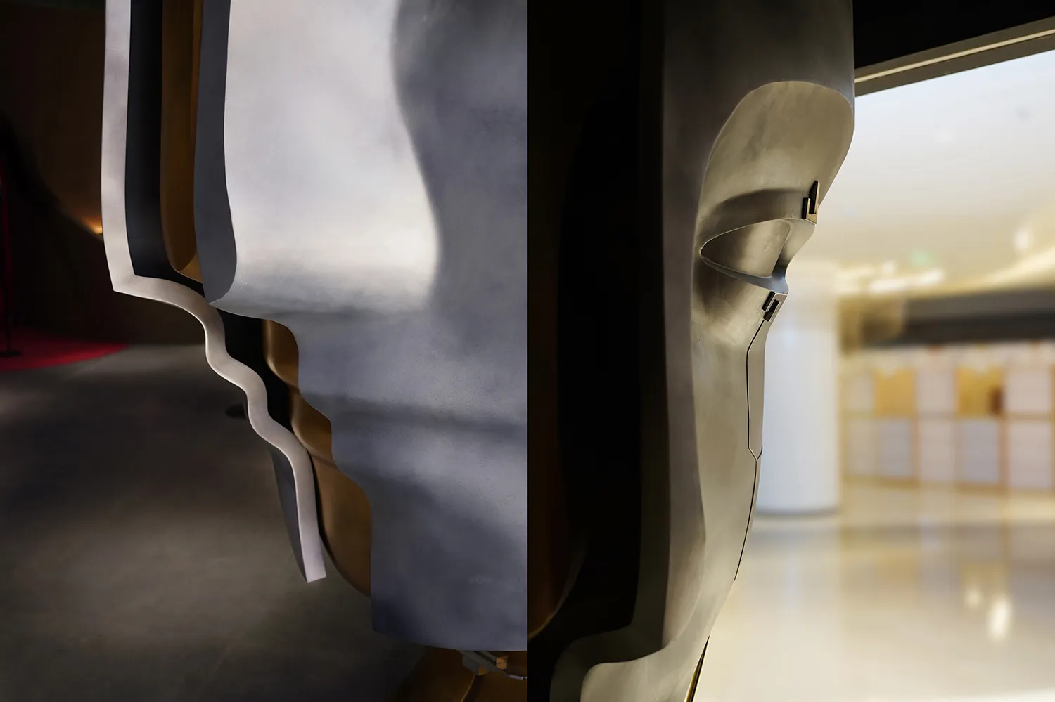 A close-up of a modern metal art piece with a wider view of the surrounding area in the background