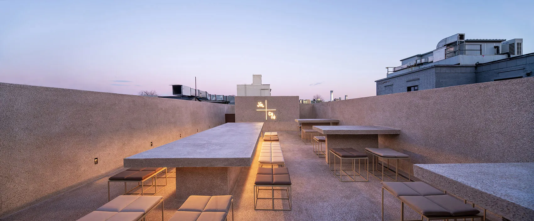 An inviting outdoor patio with multiple dining tables, benches, and chairs, perfect for social gatherings or relaxation