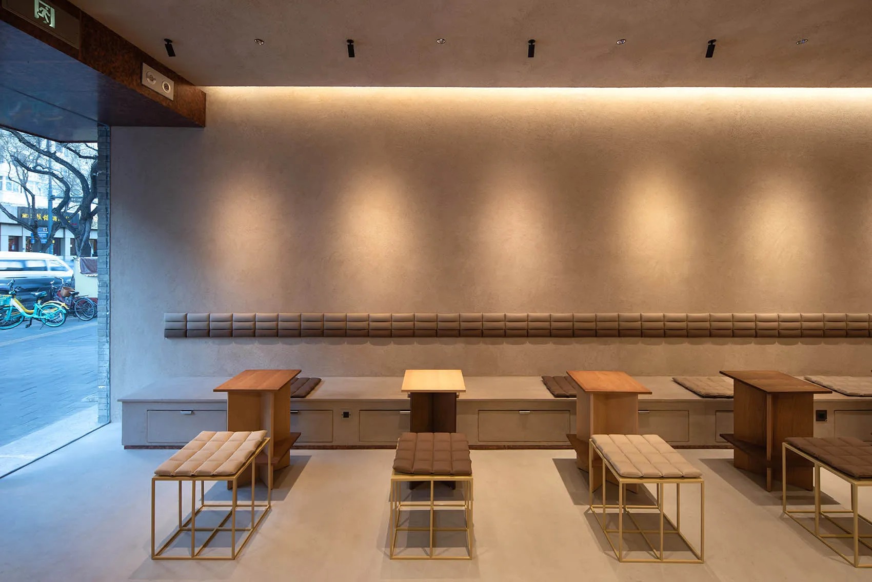 A large room with multiple dining tables and chairs, benches, and a spacious atmosphere suitable for social gatherings and events