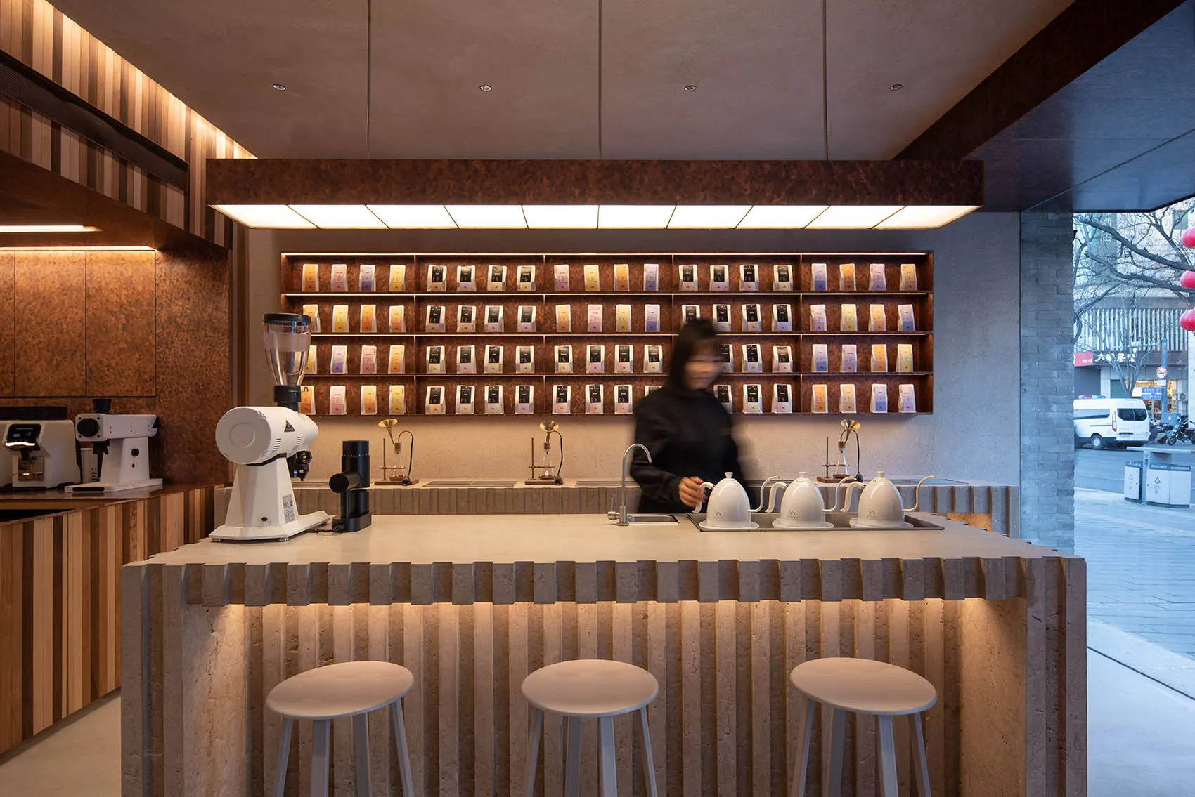A modern showroom with a counter featuring various items, including cups and bottles, in a stylish environment