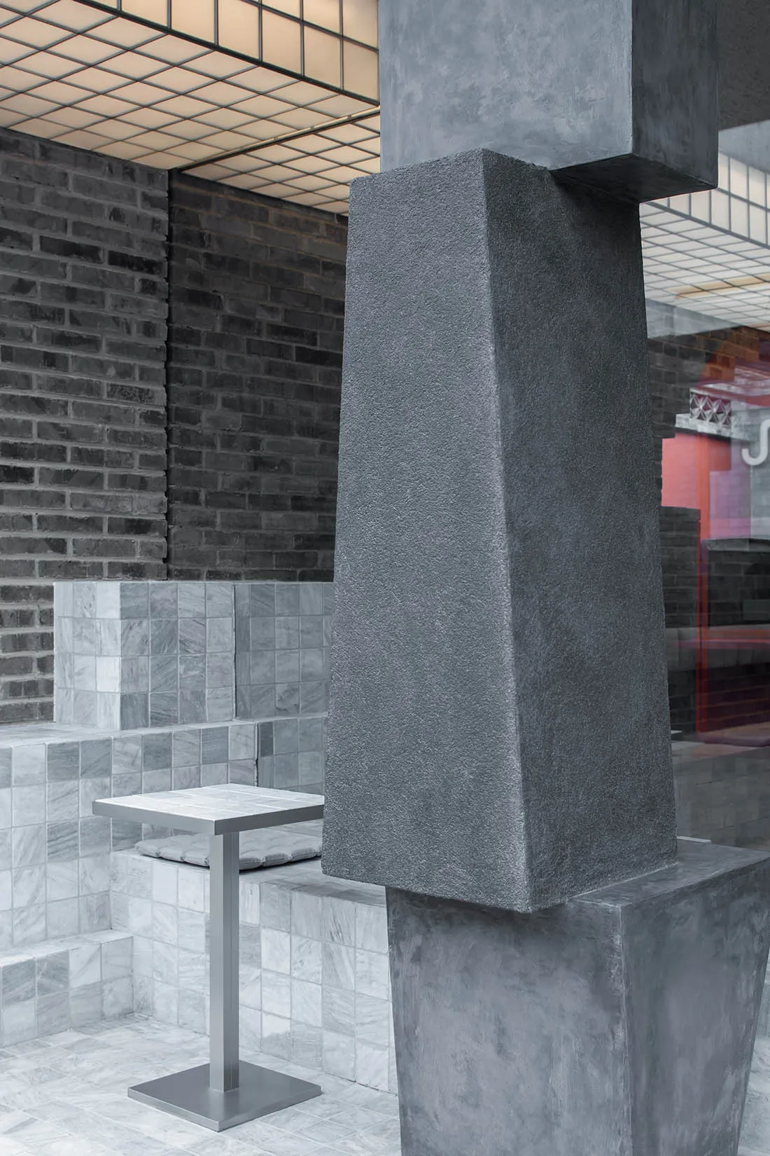 A dimly lit restaurant with brick walls, tables, and chairs, creating a cozy atmosphere