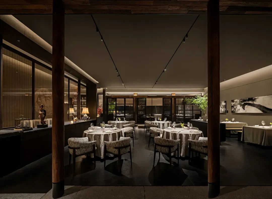 Elegant restaurant interior with multiple tables, chairs, and decorative items, creating a sophisticated atmosphere for upscale dining
